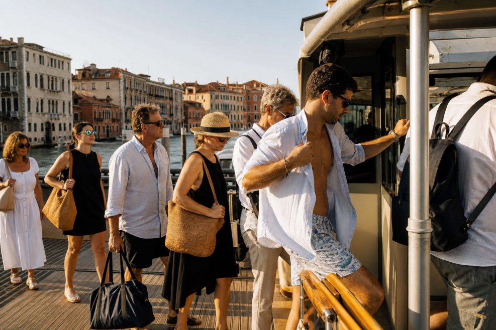 Turiști îmbrăcați adecvat înainte de urcarea în vaporetto la Veneția