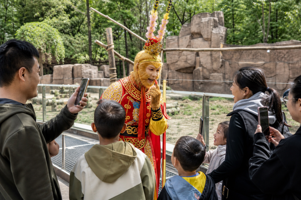Actorul Sun Wukong interacționează cu vizitatori la grădina zoologică din Changchun.