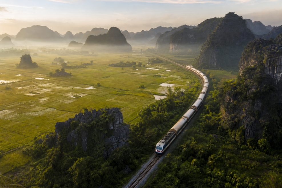 Tren turistic traversând peisajul carstic din Ninh Binh, Vietnam.